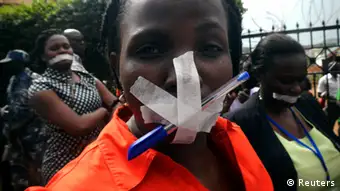 A woman journalist protests with her mouth taped shut
