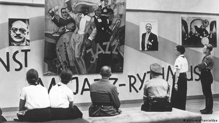 Zuschauer betrachten Exponate in der Ausstellung Entartete Musik, die als Gegenstück zur Ausstellung Entartete Kunst im Rahmen der Reichsmusik-Festwoche veranstaltet wurde