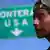 A young man next to a sign pointing to the US border (Foto: John Moore/Getty Images)
