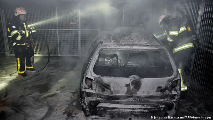 Firemen extinguish a burning car parked in an indoor garage in the Stockholm suburb of Tureberg after youths rioted in several different suburbs for a fourth consecutive night on May 24, 2013. In the suburb of Husby, where the riots began on Sunday in response to the fatal police shooting of a 69-year-old machete-wielding man, 80 percent of residents are immigrants and the unrest has highlighted Sweden's failure to integrate swathes of its immigrant population, but in this small, consensus-driven country, there was little agreement on how to solve the problem. AFP PHOTO/JONATHAN NACKSTRAND (Photo credit should read JONATHAN NACKSTRAND/AFP/Getty Images)