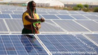 An Indian worker sprays water onto panels of India's first 1MW canal-top solar power plant at Chandrasan village of Mehsana district, some 45 kms from Ahmedabad on World Earth Day, April 22, 2012. This solar power plant on a 750 metre stretch of the Sanand Branch Canal of Sardar Sarovar Project will generate some 1.6 million units of clean electricity per year and will also prevent evaporation of some 90 lakh litres of water per year from the canal.