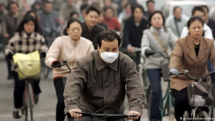 A Chinese man wears a respitory mask while riding a bicycle on a crowded street in Beijing, Thursday 03 November 2005. Next week China will host the Beijing International Renewable Energy Conference 2005 with delegations from around the world. The conference will address the impact of global warming caused by massive consumption of fossil fuels and industrial pollutants. Foto: MICHAEL REYNOLDS +++(c) dpa - Report+++