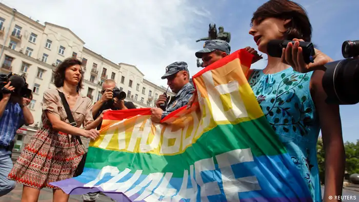 Russian police take away a banner from gay rights activists during a rally outside the mayor's office in Moscow May 25, 2013. The banner reads, Love is stronger. REUTERS/Maxim Shemetov (RUSSIA - Tags: POLITICS CIVIL UNREST)