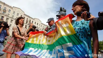 Russian police take away a banner from gay rights activists during a rally outside the mayor's office in Moscow May 25, 2013. The banner reads, Love is stronger. REUTERS/Maxim Shemetov (RUSSIA - Tags: POLITICS CIVIL UNREST)
