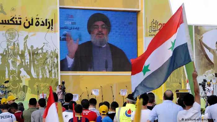 epa03717034 Supporters of Hezbollah listen to the Secretary General of Hezbollah Sayyed Hassan Nasrallah, speaking on a giant screen via video link from an undisclosed location, during a rally to mark the Resistance and Liberation Day, in the village of Mashghara, in the eastern Bekaa valley, Lebanon, 25 May 2013. The Liberation Day commemorates the Israeli army's withdrawal from south Lebanon in May 2000 following 22 years of occupation. EPA/WAEL HAMZEH pixel