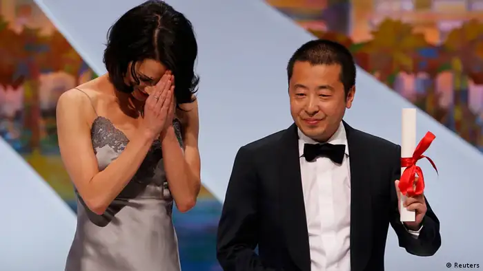 Director Jia Zhangke (R), Best screenplay award winner for the film Tian Zhu Ding (A Touch of Sin), poses on stage next to actress Asia Argento after being awarded during the closing ceremony of the 66th Cannes Film Festival in Cannes May 26, 2013. REUTERS/Eric Gaillard (FRANCE - Tags: ENTERTAINMENT)