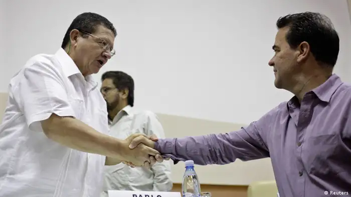 FARC negotiator Pablo Catatumbo (L) shakes hands with Colombia's government negotiator Frank Pearl during a conference in Havana May 26, 2013. Colombia and the Marxist-led FARC rebels have reached agreement on the critical issue of agrarian reform, the two sides said on Sunday in what appeared to be a major step forward for the peace process aimed at ending their long war. REUTERS/Enrique De La Osa (CUBA - Tags: POLITICS CIVIL UNREST)