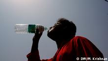 Man drinks water against the sun in New Delhi (Photo: Murali Krishnan / DW)