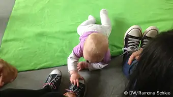 Bild 4: Baby Lara grabscht nach den Schuhen einer Schülerin