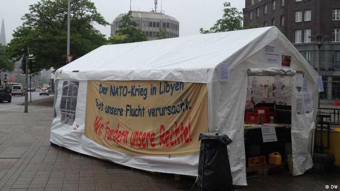 Ein weißes Zelt mit Banner und Schriftzügen. (Foto: Kathrin Erdmann/DW)