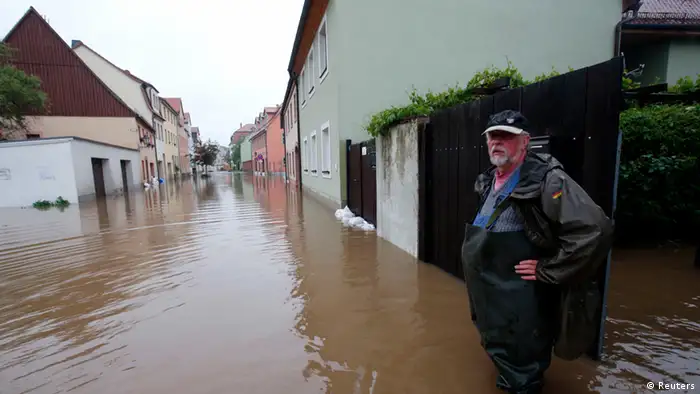 A resident stands at his property on a flooded street in the town of Grimma, near Leipzig June 2, 2013. Authorities in the German state of Saxon have declared Grimma a disaster area, according to local media. REUTERS/Fabrizio Bensch (GERMANY - Tags: DISASTER ENVIRONMENT TPX IMAGES OF THE DAY)