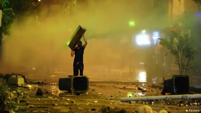 An anti-government protester carries an object during a clash with riot police in Izmir, western Turkey, June 2, 2013. Tens of thousands of people took to the streets in Turkey's four biggest cities on Sunday and clashed with riot police firing tear gas on the third day of the fiercest anti-government demonstrations in years. Picture taken June 2, 2013. REUTERS/Emre Tazegul (TURKEY - Tags: POLITICS CIVIL UNREST)