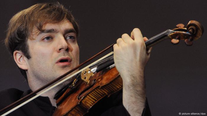 A man holds a violin