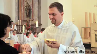 Eucharistie: ein Priester teilt die Hostien aus. picture alliance/dpa)