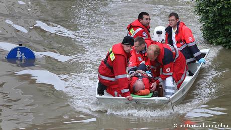 Five men wearing red jackets and riding in a boat take care of another man laying in the boat.
(Photo: Karl-Josef Hildenbrand dpa)