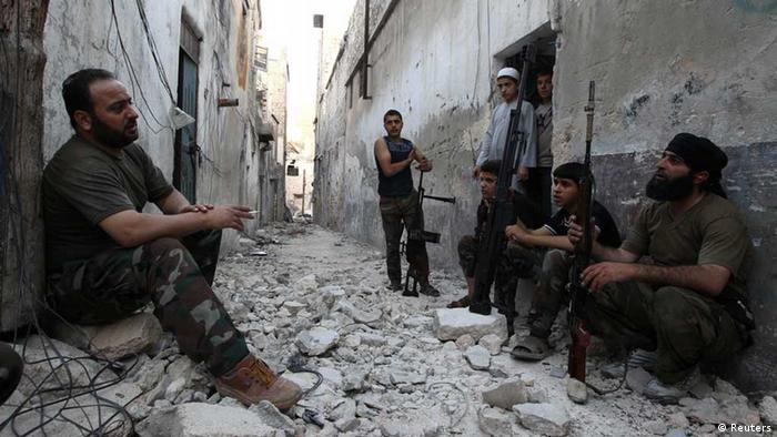 Members of the Free Syrian Army talk as they sit with their weapons REUTERS/Muzaffar Salman