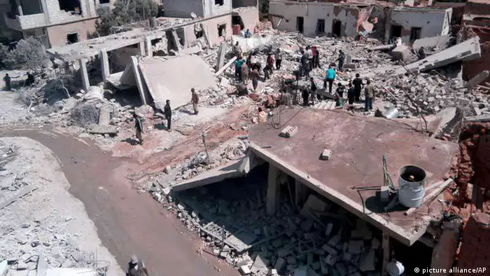 FILE - This Tuesday, May 21, 2013 file citizen journalism image provided by Qusair Lens, which has been authenticated based on its contents and other AP reporting, shows Syrian citizens gathering over houses that were destroyes from a Syrian forces air strike in the town of Qusair, near the Lebanon border, Homs province, Syria. Cut off for three weeks by a regime siege, doctors in the Syrian town of Qusair keep hundreds of wounded in storerooms and underground shop cellars, short on antibiotics and anesthesia, using unsterilized cloth for bandages and blowing air with pumps because theres no oxygen canisters, amid relentless shelling and sniper fire. More than a dozen have died from untreated wounds and at least 300 others need immediate evacuation, one doctor says. (AP Photo/Qusair Lens, File)