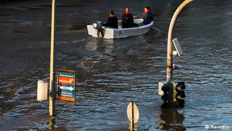 Traffic lights poke out from the water as a boat cruises by on a flooded street
(Photo: Thomas Peter/REUTERS)