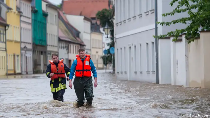 GRIMMA, GERMANY - JUNE 03: Firefighters and helpers evacuate inhabitants in the flooded city center on June 3, 2013 in Grimma, Germany. Heavy rains are pounding southern and eastern Germany, causing wide-spread flooding and ruining crops. At least two people are missing and feared dead in what is evolving into the most serious flood levels since the so-called 100-year flood of 2002. Portions of Austria and the Czech Republic are also inundated. (Photo by Jens Schlueter/Getty Images)