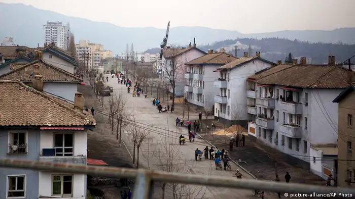North Koreans walk bicycles along a street in Kaesong, North Korea, north of the demilitarized zone which separates the two Koreas, Tuesday, April 23, 2013. (AP Photo/David Guttenfelder)