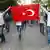 Anti-government protesters hold up a Turkish flag as they demonstrate in the center of Ankara, Turkey on June 6, 2013. Turkish Prime Minister Recep Tayyip Erdogan said on June 6 that members of a 'terrorist organisation' were taking part in deadly anti-government protests sweeping Turkey and refused to cancel a controversial Istanbul development plan that sparked them. Protesters accuse Erdogan of imposing conservative Islamic reforms on Turkey, a mostly Muslim but constitutionally secular country. AFP PHOTO / ADEM ALTAN (Photo credit should read ADEM ALTAN/AFP/Getty Images)