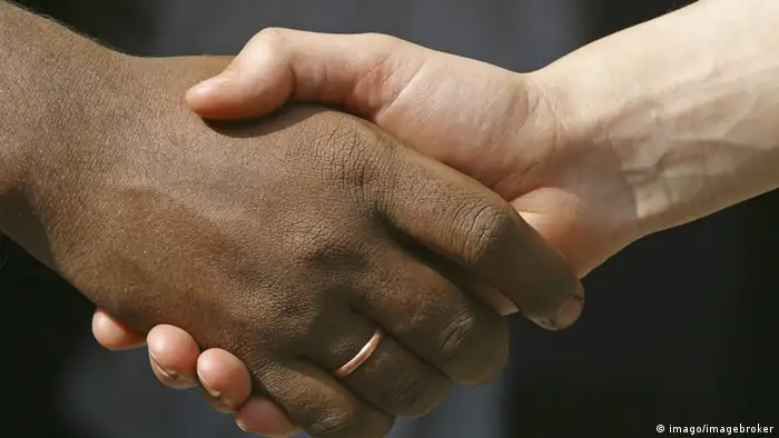 A black and a white hand shaking