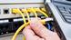 One of a number of yellow ethernet cables is plugged into a black laptop computer (Photo: no info) One of a number of yellow ethernet cables is plugged into a black laptop computer (Photo: no info)