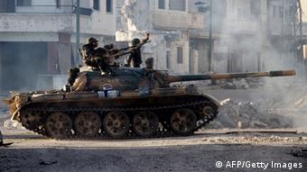 Syrian army troops drive through the ravaged streets of Qusair in the central Homs province on June 5, 2013, after government forces seized total control of the former rebel-stronghold. The United States condemned the assault by Syrian troops on Qusayr, claiming the regime had had to depend on the Lebanese militant group Hezbollah to win the battle, causing tremendous suffering during a blistering 17-day assault which ended in a major battlefield success for regime forces in a war that has killed at least 94,000 people. AFP PHOTO / STR (Photo credit should read -/AFP/Getty Images)