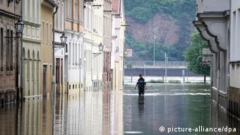 Ein Mann geht am 09.06.2013 in der vom Elbehochwasser betroffenen Stadt Meißen (Sachsen) durch einen Überschwemmten Straßenzug (Foto: Kay Nietfeld/dpa)