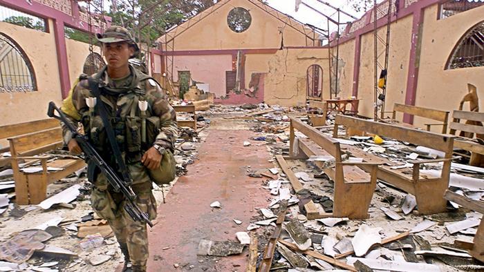 A Colombian soldier crosses a destroyed church 