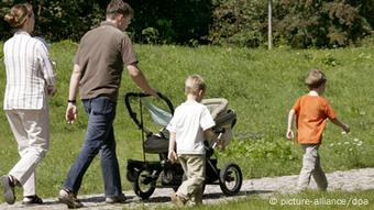 Eltern gehen bei schönem Wetter mit ihren Kindern im Park in Halle/Saale spazieren (Foto: Waltraud Grubitzsch/dpa)