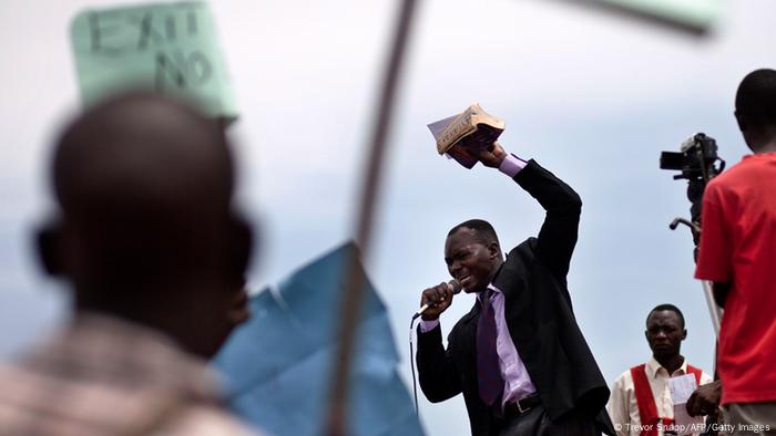 A clergyman is seen with a bible in his hand preaching against LGBT rights