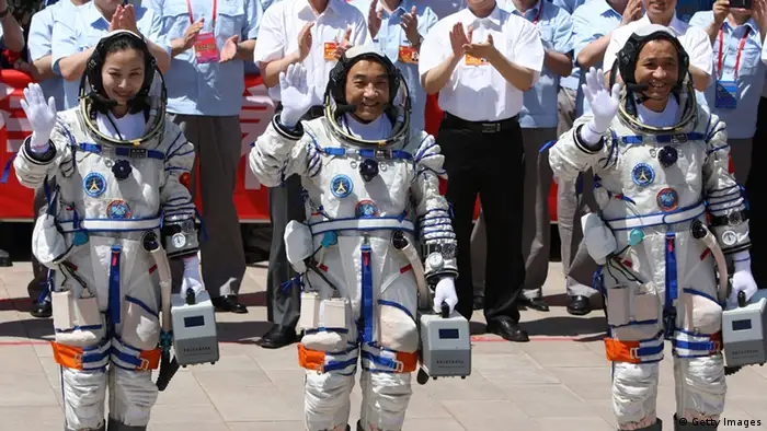 Chinese astronauts (L-R) Wang Yaping, Zhang Xiaoguang and mission commander Nie Haisheng wave to onlookers as they prepare to board the Shenzhou-10 spacecraft in Jiuquan, northwest China's Gansu on June 11, 2013. China was to launch its longest-ever manned space mission on June 11, with its second woman astronaut among the crew, as it steps up its ambitious space programme, a symbol of the country's growing power. CHINA OUT AFP PHOTO (Photo credit should read AFP/AFP/Getty Images)