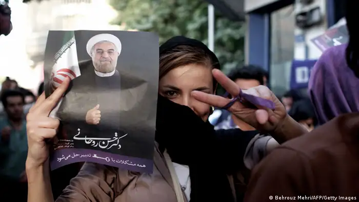 An Iranian woman flashes the sign for victory as she holds a portrait of moderate presidential candidate Hassan Rowhani during celebrations after he won the Islamic Republic's presidential elections in downtown Tehran on June 15, 2013. Iranian Interior Minister Mohammad Mostafa Najjar said Rowhani won outright with 18.6 million votes, or 50.68 percent. AFP PHOTO/BEHROUZ MEHRI (Photo credit should read BEHROUZ MEHRI/AFP/Getty Images)