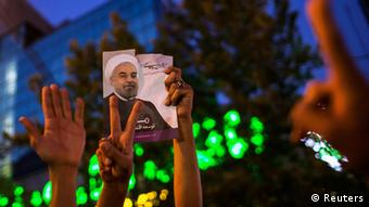 Erhobene Hände und ein Rohani-Plakat: Anhänger feiern den Wahlsieg (Foto: REUTERS/Fars News)