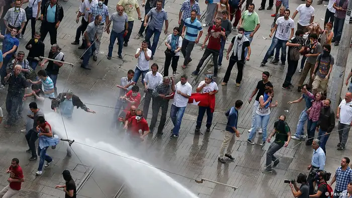 Riot police use a water cannon to disperse anti-government protesters at Taksim square in central Istanbul June 16, 2013. Thousands of people took to the streets of Istanbul overnight on Sunday, erecting barricades and starting bonfires, after riot police firing teargas and water cannon stormed a park at the centre of two weeks of anti-government unrest. Lines of police backed by armoured vehicles sealed off Taksim Square in the centre of the city as officers raided the adjoining Gezi Park late on Saturday, where protesters had been camped in a ramshackle settlement of tents. REUTERS/Osman Orsal (TURKEY - Tags: CIVIL UNREST POLITICS)