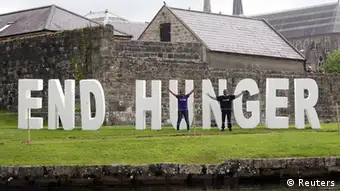 epa03748730 G8 Protesters stand in front of a sign reading 'End Hunger' at Enniskillen Castle, during the G8 Summit in Lough Erne, Britain, 17 June 2013. Leaders from Canada, France, Germany, Italy, Japan, Russia, USA and UK are meeting at Lough Erne in Northern Ireland for the G8 Summit running from 17 until 18 June. EPA/AIDAN O'REILLY pixel