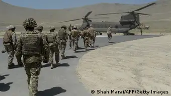 NATO soldiers board a Chinook helicopter after a security handover ceremony at a military academy outside Kabul on June 18, 2013. Afghan forces took control of security across the country on June 18, marking a major milestone as US-led combat troops prepare to withdraw after 12 years of fighting the Taliban. Speaking at a military academy outside Kabul, President Hamid Karzai said the police and army were ready to take on insurgents, but a bomb in the city underlined persistent instability. AFP PHOTO/ SHAH Marai (Photo credit should read SHAH MARAI/AFP/Getty Images)