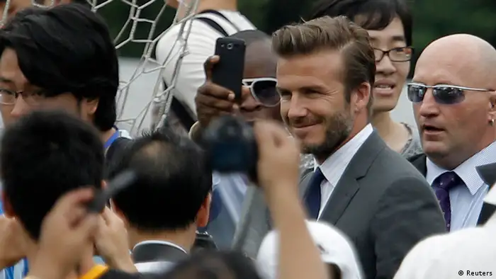Former England captain David Beckham (obscured) arrives at Tongji University surrounded by his fans in Shanghai June 20, 2013. Beckham cancelled his event at Tongji University after a stampede accident happened upon his arrival injuring at least five people on Thursday, local media reported. REUTERS/Aly Song (CHINA - Tags: SPORT SOCCER)