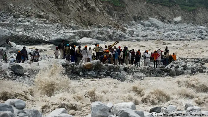 Indo-Tibetan Border Police (ITBP) personnel and local residents pull a rope to rescue stranded pilgrims on the other side of a river at Govind Ghat on June 23, 2013. Rescue operations have intensified in northern India where up to 1,000 people are feared to have died in landslides and flash floods that have also left pilgrims and tourists stranded without food or water for days. AFP PHOTO/MANAN VATSYAYANA (Photo credit should read MANAN VATSYAYANA/AFP/Getty Images)