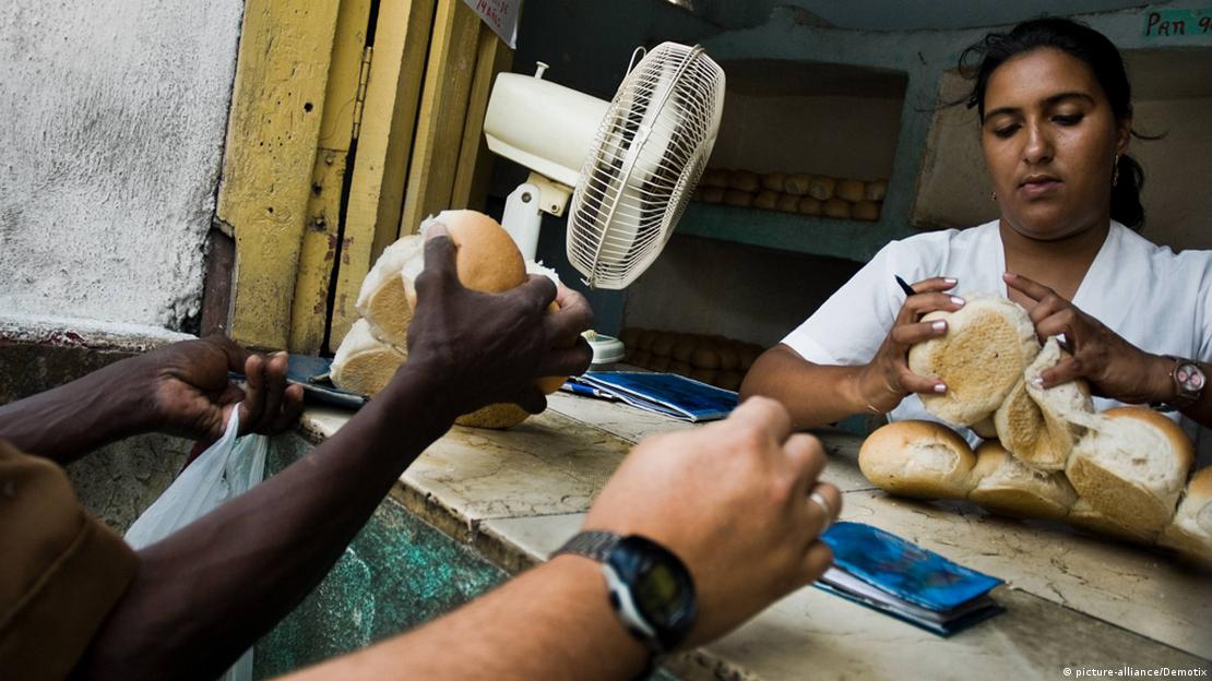 Funcionária de bodega reparte pães subsidiados para entregar a cubanos Funcionária de bodega reparte pães subsidiados para entregar a cubanos