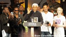 Former South African president Nelson Mandela (C) speaks during the 46664 concert in honour of his 90th birthday in Hyde Park, central London, on June 27, 2008. The three-hour gig, headlined by veteran rockers Queen alongside the likes of Razorlight and Simple Minds, will also support Mandela's 46664 campaign against HIV/AIDS. AFP PHOTO / Shaun Curry (Photo credit should read SHAUN CURRY/AFP/Getty Images)