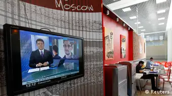 A television screen shows former U.S. spy agency contractor Edward Snowden during a news bulletin at a cafe at the Moscow's Sheremetyevo airport June 26, 2013. Russian President Vladimir Putin confirmed on Tuesday a former U.S. spy agency contractor sought by the United States was in the transit area of a Moscow airport but ruled out handing him to Washington, dismissing U.S. criticisms as ravings and rubbish. REUTERS/Sergei Karpukhin (RUSSIA - Tags: POLITICS SOCIETY TRANSPORT)