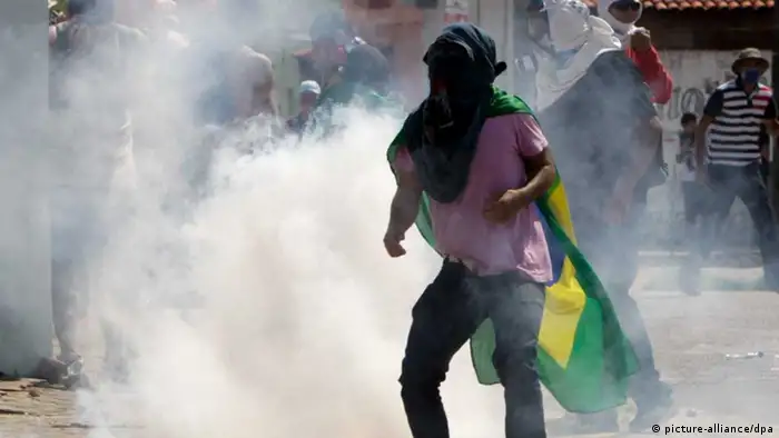 Protesters amid tear gas fired by Brazilian police during demonstrations near Castelao Arena in Fortaleza, Brazil, 27 June 2013. Police blocked the area around the stadium which will host the Confederations Cup semi-final 2013 between Spain and Italy. Five people have died during the social protests that began on 10 June in Sao Paulo and spread across the country (photo: epa/Fernando Bizerra jr.).