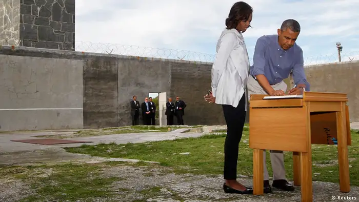 U.S. President Barack Obama writes in a guest book as he tours Robben Island with first lady Michelle Obama, near Cape Town, June 30, 2013. Under apartheid, Nelson Mandela spent several decades as a political prisoner on Robben Island. REUTERS/Jason Reed (SOUTH AFRICA - Tags: POLITICS TPX IMAGES OF THE DAY)