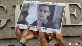Protesters in support of Edward Snowden, a contractor at the National Security Agency (NSA), hold a photo of him during a demonstration outside the U.S. Consulate in Hong Kong in this June 13, 2013 file photo. Snowden, left Hong Kong on a flight for Moscow on June 23, 2013 and his final destination may be Ecuador or Iceland, the South China Morning Post said. REUTERS/Bobby Yip/Files (CHINA - Tags: POLITICS CIVIL UNREST)