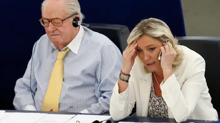 Marine Le Pen (R), France's far-right National Front political party leader, speaks on the phone as she attends a voting session at the European Parliament beside her father Jean-Marie Le Pen in Strasbourg, July 2, 2013. The leader of France's far-right National Front lost her right to legal immunity as a European Parliament deputy on Tuesday, exposing her to possible prosecution over a racism charge. Marine Le Pen's loss of immunity came at the request of a Lyon court three years after she was accused of inciting racial hatred for comparing Muslim street prayers to the occupation of France by Nazi Germany. REUTERS/Vincent Kessler (FRANCE - Tags: POLITICS)