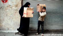 ARCHIV - Eine syrische Frau und ihr Sohn tragen Kartons mit Lebensmitteln am 19.02.2013 in Aleppo. Nach mehr als zwei Jahren Konflikt in Syrien fehlt es der Bevölkerung an allem. Hilfsorganisationen schlagen Alarm EPA/BRUNO GALLARDO (zu dpa «Syrien in Not - Lebensmittel immer knapper, heftige Kämpfe» vom 15.05.2013) +++(c) dpa - Bildfunk+++