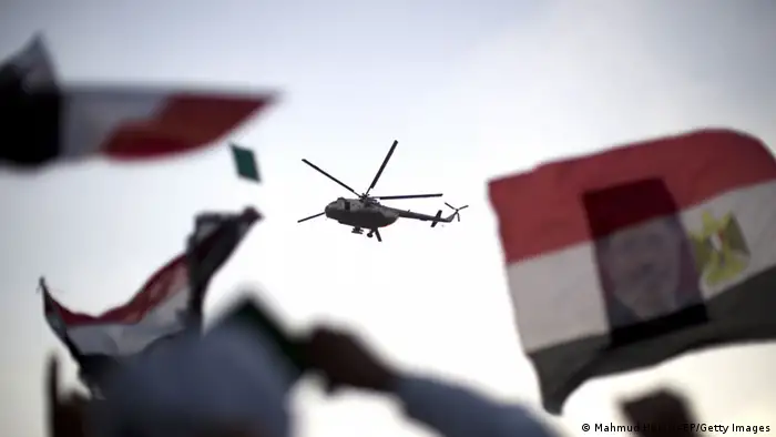 An Egyptian military helicopter hovers over supporters of the Muslim Brotherhood during a rally in support of deposed president Mohamed Morsi outside Cairo's Rabaa al-Adawiya mosque on July 5, 2013. Supporters of ousted Egyptian president Mohamed Morsi took to the streets in their tens of thousands, defying his army deposers and triggering running clashes that killed at least three people. AFP PHOTO/MAHMUD HAMS (Photo credit should read MAHMUD HAMS/AFP/Getty Images)
