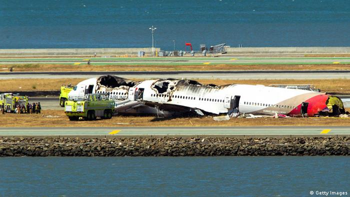SAN FRANCISCO, CA - JULY 6: A fireman and investigator examine the tail wreckage from a Boeing 777 airplane that crashed while landing at San Francisco International Airport July 6, 2013 in San Francisco, California. An Asiana Airlines passenger aircraft coming from Seoul, South Korea crashed while landing. Two fatalities have so far been reported. (Photo by Kimberly White/Getty Images)